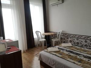 a bedroom with a bed and a table and chairs at Miraj-MD in Primorsko