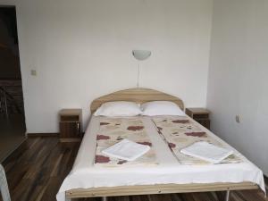 um quarto com uma cama com lençóis brancos e almofadas em Miraj-MD em Primorsko