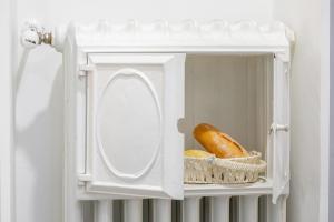 a white medicine cabinet with a mirror and a loaf of bread at La Terrazza di Como in Como