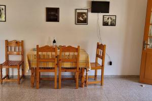 una sala da pranzo con tavolo, sedie e televisione di Stamatis studio with seaview - Lakka Paxos a Lákka