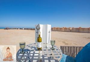 a table with a bottle of wine and glasses on the beach at Fabulous Penthouse seaview wifi in Boutique resort in Hurghada