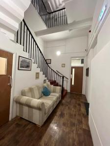 a living room with a couch and a staircase at Lovely One Bedroom Apartment in Rotherham