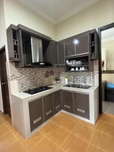 a kitchen with brown cabinets and a counter top at Homestay Rohmat in Kota Bharu