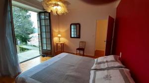 a bedroom with a bed and a large window at Maison de 5 chambres avec vue sur la ville et jardin clos a Langogne in Langogne