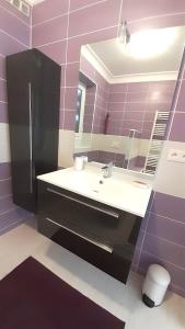 a bathroom with a sink and a mirror and purple tiles at Maison de 5 chambres avec vue sur la ville et jardin clos a Langogne in Langogne