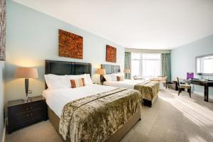 a hotel room with two beds and a desk at Cork International Hotel in Cork