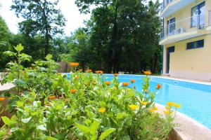 a house and a swimming pool with flowers next to it at Pop Art Hotel in Primorsko +32 photos