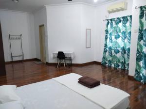 a white room with a bed and a chair at Sapporo Homestay in Skudai