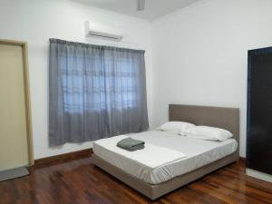 a bed in a room with a large window at Sapporo Homestay in Skudai