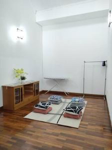 a room with three pillows on the floor and a table at Sapporo Homestay in Skudai +2 photos