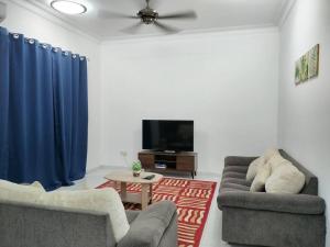 a living room with two chairs and a flat screen tv at Sapporo Homestay in Skudai