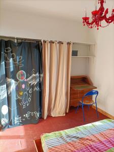 a bedroom with a curtain and a table and a bed at T2 centre village "Chez Clothilde" in Remoulins