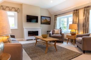 a living room with a couch and a fireplace at Cowdray Lodge in Midhurst