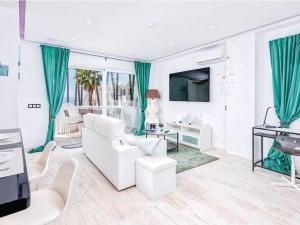 a living room with white furniture and green curtains at Charming apartment in Mijas in Mijas