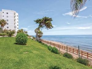 a beach with a fence and a building and the ocean at Charming apartment in Mijas in Mijas