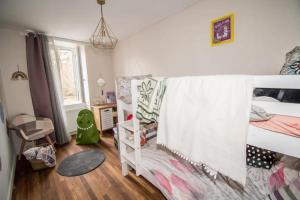 a bedroom with two bunk beds and a window at Les dames du pont in Pontgibaud