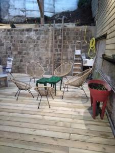 une terrasse avec des chaises, une table et une échelle dans l'établissement Les dames du pont, à Pontgibaud