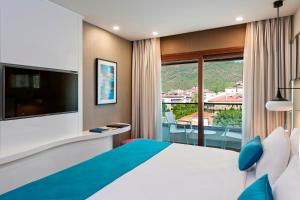 um quarto de hotel com uma cama grande e uma varanda em Elite World Marmaris - Adult Only em Marmaris