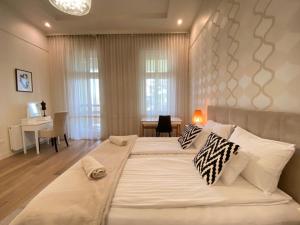 Cama blanca grande en habitación con mesa en Romantic riverview bestern en Szeged