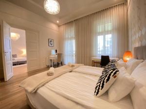 塞格德Romantic riverview Bestern的卧室配有一张大白色的床和书桌