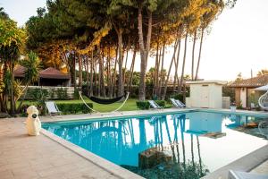 a dog is sitting next to a swimming pool at Villa Laoconte piscina, jacuzzi e biliardo in Canicattì