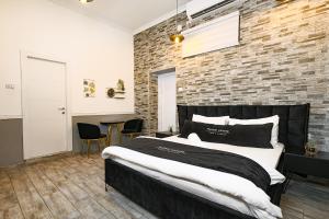 a bedroom with a large bed and a brick wall at אחוזת רפאל in Tiberias