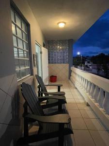 two chairs sitting on a balcony at night at Playa Apartments in Salinas