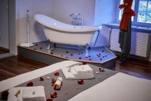 La salle de bains est pourvue d'un lavabo et d'une baignoire avec des roses. dans l'établissement Auberge de Bellelay, à Bellelay