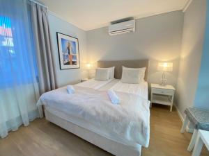 sypialnia z dużym białym łóżkiem z 2 poduszkami w obiekcie Hip riverview bestern w Segedynie