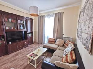 a living room with a couch and a tv at Villa Laoconte piscina, jacuzzi e biliardo in Canicattì