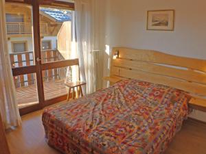 sypialnia z łóżkiem i balkonem w obiekcie T2 cosy, proche centre Samoëns, animaux admis, parking - FR-1-629-67 w mieście Samoëns