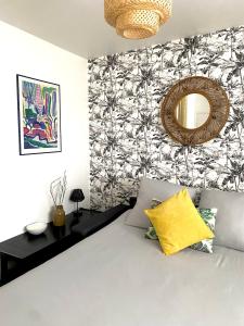 Schlafzimmer mit einem Bett und einem Wandspiegel in der Unterkunft Le Minimes-Studio Proche - Self check-In & Parking privée in Toulouse