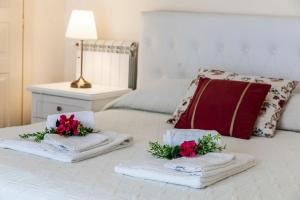 un letto con asciugamani e fiori sopra di Villa Laoconte piscina, jacuzzi e biliardo a Canicattì