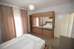 都拉斯的住宿－Vila Emma，一间卧室配有一张床和一面大镜子