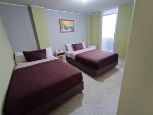 a hotel room with two beds and a window at HOTEL DINO in Pasto