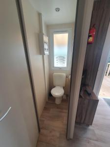 a small bathroom with a toilet and a window at Team Holiday - Camping du Petit Pont in Arvert