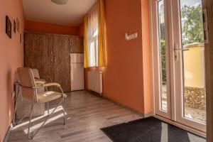 a room with a table and a chair and a window at Garden Vendégház Makó in Makó