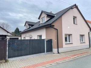 una casa blanca con una valla negra en Apartmán Světla, en Pardubice