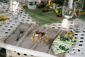 a white table with a plate of food and wine glasses at Villa Laoconte piscina, jacuzzi e biliardo in Canicattì