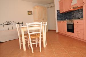 uma cozinha com mesa e cadeiras num quarto em Il Borgo Di Punta Marana em Golfo Aranci