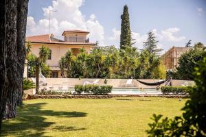 a house with a hammock in front of a yard at Villa Laoconte piscina, jacuzzi e biliardo in Canicattì