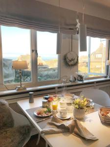 einen Tisch mit Essen drauf in einer Küche mit Fenstern in der Unterkunft Ocean-View, Holiday Apartment Sylt in Rantum