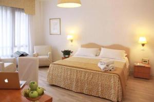 a bedroom with a bed and a living room with a laptop at Residenza Giacomuzzi in Mestre