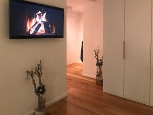 sala de estar con TV en la pared y chimenea en Ocean-View-I-Holiday-Apartments-Sylt, en Rantum