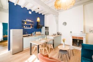 a kitchen and living room with a table and chairs at Le Mont Brenn in Auxerre