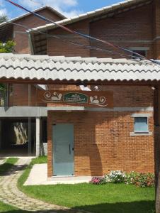 ein Backsteingebäude mit einem Schild, das die Gartenakademie liest in der Unterkunft Chalés Estrada Real in Conceição da Ibitipoca