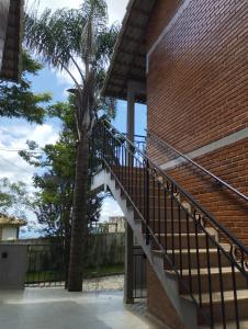 eine Treppe, die zu einem Backsteingebäude mit einer Palme führt in der Unterkunft Chalés Estrada Real in Conceição da Ibitipoca