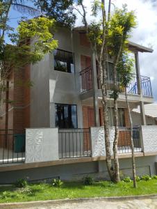 apartamentowiec z balkonem i drzewami w obiekcie Chalés Estrada Real w mieście Conceição da Ibitipoca