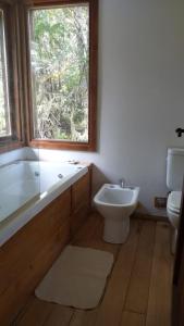 y baño con bañera, aseo y lavamanos. en Cabaña Refugio de Viento en Tolhuin
