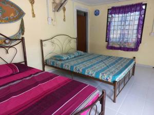 a bedroom with two beds and a window at Tmn Rekreasi Cikgu Haron in Labis